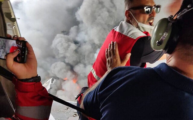 A handout picture provided by the Iranian Red Crescent (RCS) on April 27, 2025, shows members of a rescue team arriving by helicopter at the scene of an explosion that took place a day earlier at the Shahid Rajaee port dock southwest of Bandar Abbas in the Iranian province of Hormozgan (Iranian Red Crescent / AFP)