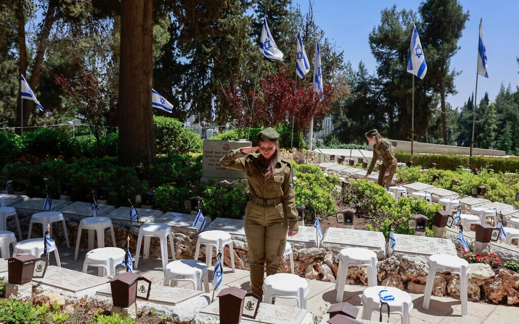 Israeli soldiers salute after placing the national flag on the graves of fellow soldiers at the Mount Herzl military cemetery in Jerusalem on April 28, 2025, ahead of the Memorial Day (Menahem KAHANA / AFP)