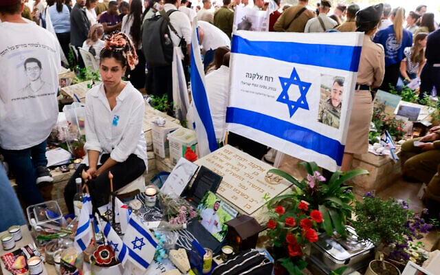 People visit the graves of Israeli soldiers during the Memorial Day commemoration for fallen soldiers at the Mount Herzl military cemetery in Jerusalem on April 30, 2025. (Photo by Menahem Kahana / AFP)