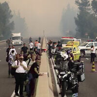 People are evacuated from a highway during a forest fire near the central Israeli town of Bet Shemesh on April 30, 2025. (Photo by Ahmad GHARABLI / AFP)