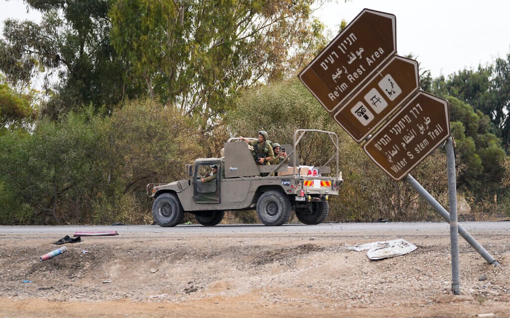 Israeli soldiers drive by the Supernova rave party site, where almost 380 were killed, near Kibbutz Re'im, close to the Gaza Strip border fence, on October 10, 2023. (AP Photo/Ohad Zwigenberg)