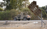 Israeli soldiers drive by the Supernova rave party site, where almost 380 were killed, near Kibbutz Re'im, close to the Gaza Strip border fence, on October 10, 2023. (AP Photo/Ohad Zwigenberg)