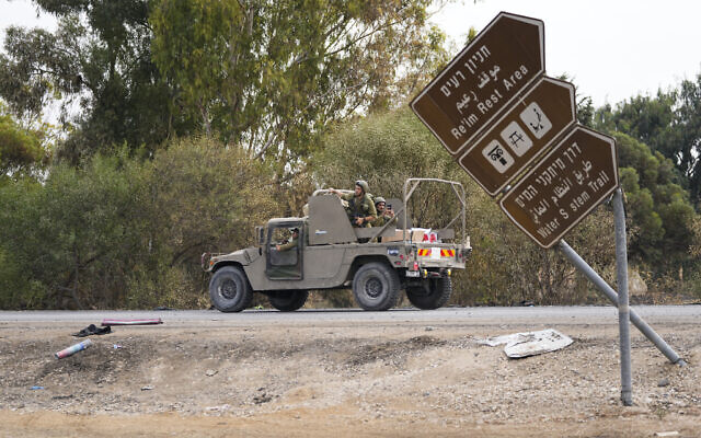 Israeli soldiers drive by the Supernova rave party site, where almost 380 were killed, near Kibbutz Re'im, close to the Gaza Strip border fence, on October 10, 2023. (AP Photo/Ohad Zwigenberg)