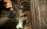 Israeli soldiers escort the media to an underground tunnel found underneath Shifa Hospital in Gaza City, Nov. 22, 2023. (AP/Victor R. Caivano)