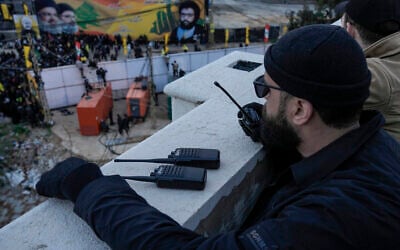 A Hezbollah member speaks on walkie-talkie during a funeral procession of Hezbollah's former leader, Hassan Nasrallah, and his cousin and successor, Hashem Safieddine at the burial site in Beirut's southern suburbs, Lebanon, February 23, 2025. (AP Photo/Bilal Hussein)