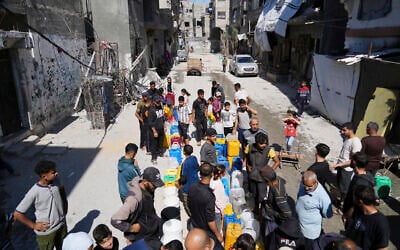 Palestinians line up to fill cans with water in Jabaliya, northern Gaza Strip, March 16, 2025. (AP Photo/Abdel Kareem Hana)