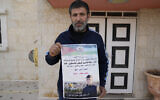 Khalid Ahmad holds a poster of his 17-year-old son, Waleed, who died in an Israeli prison, that reads in Arabic, 'The hero prisoner Martyr, mercy and eternity for our righteous Martyrs,' in the West Bank town of Silwad, northeast of Ramallah March 26, 2025. (Nasser Nasser/AP)