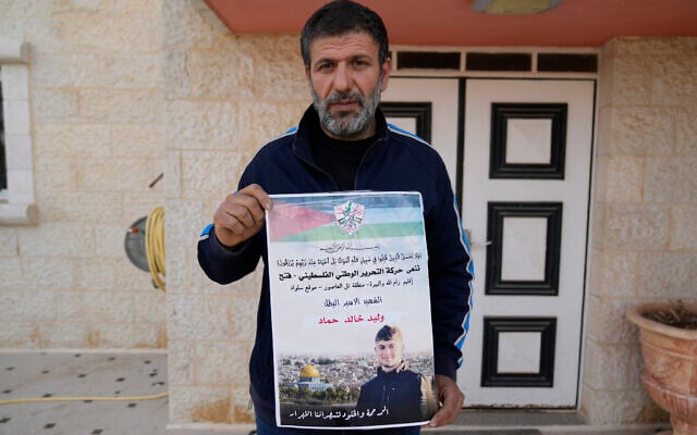 Khalid Ahmad holds a poster of his 17-year-old son, Waleed, who died in an Israeli prison, that reads in Arabic, 'The hero prisoner Martyr, mercy and eternity for our righteous Martyrs,' in the West Bank town of Silwad, northeast of Ramallah March 26, 2025. (Nasser Nasser/AP) Khalid Ahmad holds a poster of his 17-year-old son, Waleed, who died in an Israeli prison, that reads in Arabic, 'The hero prisoner Martyr, mercy and eternity for our righteous Martyrs,' in the West Bank town of Silwad, northeast of Ramallah March 26, 2025. (Nasser Nasser/AP)