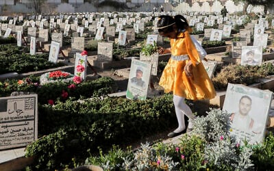 A Yemeni girl visits the graves of Houthis during Eid al-Fitr marking the end of the holy fasting month of Ramadan in Sanaa, Yemen, March 30, 2025. (Osamah Abdulrahman/AP)