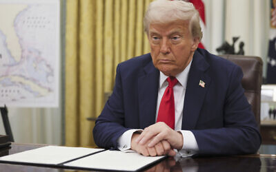 US President Donald Trump listens to a question from a reporter before signing an executive order in the Oval Office of the White House in Washington, on March 31, 2025. (Pool via AP)