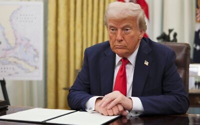 US President Donald Trump listens to a question from a reporter before signing an executive order in the Oval Office of the White House in Washington, March 31, 2025. (Pool via AP)