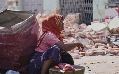 A beef vendor waits for customers at a local bazaar near a building damaged by the earthquake in Naypyitaw, Myanmar, Tuesday, April 1, 2025. (AP Photo)