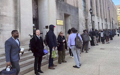 Hundreds of employees wait in line wrapped around the outside of the Health and Human Services headquarters building, in Washington, April 1, 2025. (Amanda Seitz/AP)