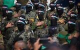 Hamas terrorists stand in formation ahead of a ceremony to hand over Israeli hostages to the Red Cross in Nuseirat, central Gaza Strip, February 22, 2025. (AP Photo/ Abdel Kareem Hana, File)