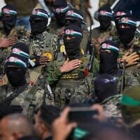 Hamas terrorists stand in formation ahead of a ceremony to hand over Israeli hostages to the Red Cross in Nuseirat, central Gaza Strip, February 22, 2025. (AP Photo/ Abdel Kareem Hana, File)