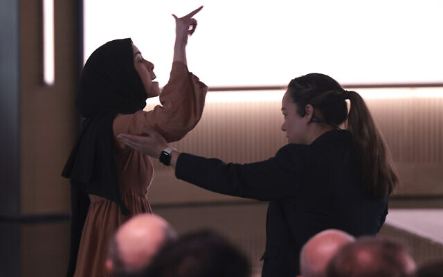 A pro-Palestinian demonstrator, Ibtihal Aboussad, is escorted away by security as she interrupts Microsoft AI CEO Mustafa Suleyman during a presentation of the company's AI assistant, Copilot, ahead of a 50th Anniversary presentation at Microsoft headquarters, April 4, 2025, in Redmond, Washington. (AP Photo/ Jason Redmond)