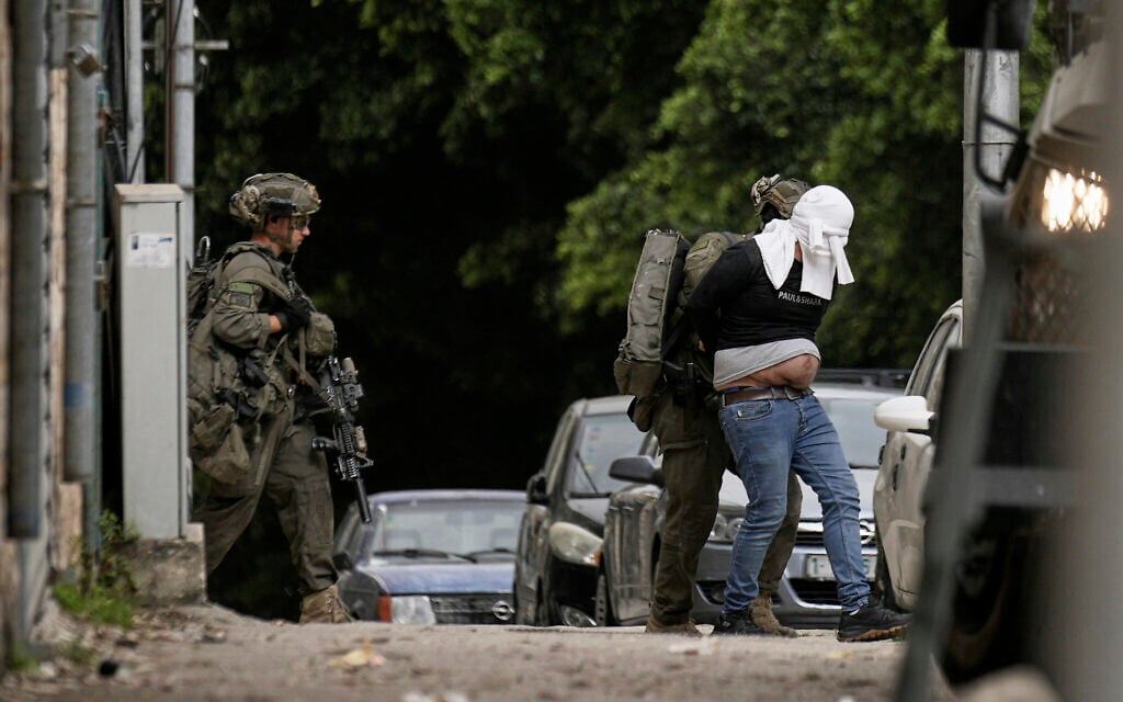 Israeli soldiers arrest a blindfolded Palestinian during an army raid in Nablus, West Bank, on Tuesday, April 8, 2025. (AP/Majdi Mohammed)