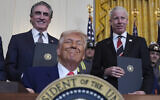 US President Donald Trump smiles as he signs executive orders as Interior Secretary Doug Burgum and Energy Secretary Chris Wright watch during an event in the East Room of the White House, in Washington, April 8, 2025. (Evan Vucci/AP)