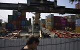 A boy looks at shipping containers in Haifa's port , Israel, Wednesday, April 9, 2025. (AP Photo/Ariel Schalit)