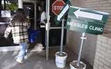 Health department staff members enter the Andrews County Health Department measles clinic carrying doses of the measles, mumps and rubella vaccine, April 8, 2025, in Andrews, Texas. (AP Photo/Annie Rice)