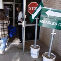 Health department staff members enter the Andrews County Health Department measles clinic carrying doses of the measles, mumps and rubella vaccine, April 8, 2025, in Andrews, Texas. (AP Photo/Annie Rice)