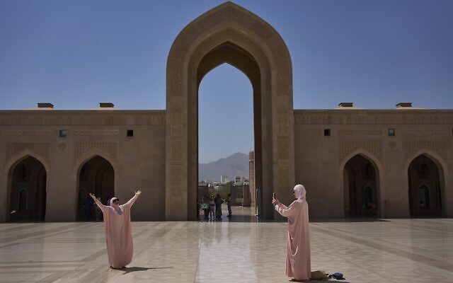 Tourists take photos at the Sultan Qaboos Grand Mosque in Muscat, Oman, Saturday, April 12, 2025. (AP Photo/ Fatima Shbair)