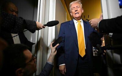 US President Donald Trump speaks to reporters aboard Air Force One on the way to Miami, Florida, April 12, 2025. (Pool via AP)