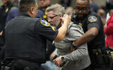 A protester is removed as US Representative Marjorie Taylor Greene speaks during a town-hall style meeting on April 15, 2025, in Acworth, Gorgia. (AP Photo/Mike Stewart)