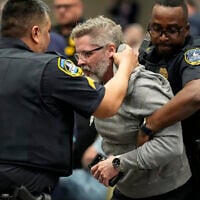 A protester is removed as US Representative Marjorie Taylor Greene speaks during a town-hall style meeting on April 15, 2025, in Acworth, Gorgia. (AP Photo/Mike Stewart)