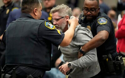 A protester is removed as US Representative Marjorie Taylor Greene speaks during a town-hall style meeting on April 15, 2025, in Acworth, Gorgia. (AP Photo/Mike Stewart)
