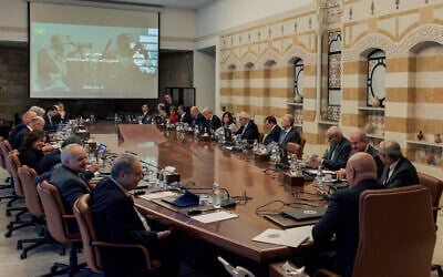 Lebanese president Joseph Aoun, center foreground, and Lebanese Prime Minister Nawaf Salam, right, head a cabinet meeting at the presidential palace in Baabda, east of Beirut, Lebanon, Thursday, April 17, 2025. The Arabic on the screen reads, "Summary of the situation and security measures taken." (Lebanese Presidency press office via AP)