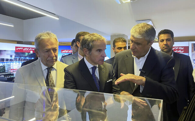 In this photo released by the Atomic Energy Organization of Iran, International Atomic Energy Agency (IAEA) Director General, Rafael Mariano Grossi, center, listens to head of the Atomic Energy Organization of Iran Mohammad Eslami as he visits an exhibition of Iran's nuclear achievements, in Tehran, Iran, Thursday, April 17, 2025. (Atomic Energy Organization of Iran via AP)