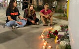 People sit in front of a makeshift memorial outside the student union at Florida State University, Thursday, April 17, 2025, in Tallahassee, Florida following a campus shooting. (AP Photo/Kate Payne)
