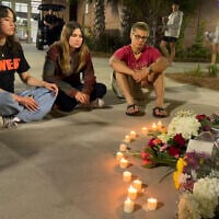 People sit in front of a makeshift memorial outside the student union at Florida State University, Thursday, April 17, 2025, in Tallahassee, Florida following a campus shooting. (AP Photo/Kate Payne)