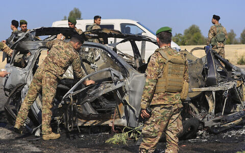Lebanese army soldiers inspect a charred car that was hit by an Israeli strike, near the coastal city of Sidon, Lebanon, Friday, April 18, 2025. (AP Photo/Mohammed Zaatari)