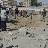 Yemenis watch a crater of a explosion at Magel Al-Dammah cemetery a day after it was hit by US airstrikes in Sanaa, Yemen, Sunday, April 20, 2025. (AP Photo)
