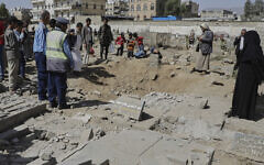 Yemenis watch a crater of a explosion at Magel Al-Dammah cemetery a day after it was hit by US airstrikes in Sanaa, Yemen, Sunday, April 20, 2025. (AP Photo)