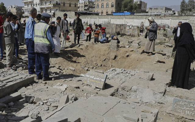 Yemenis watch a crater of a explosion at Magel Al-Dammah cemetery a day after it was hit by US airstrikes in Sanaa, Yemen, Sunday, April 20, 2025. (AP Photo)