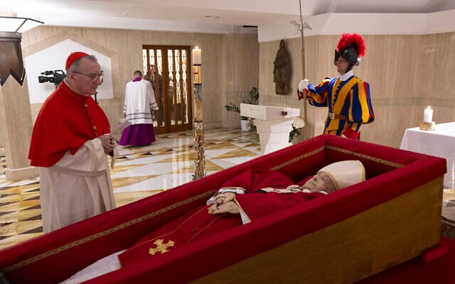 Vatican Secretary of State Cardinal Pietro Parolin, left, prays in front of the body of Pope Francis laid out in state inside his private chapel at the Vatican, April 21, 2025. (Vatican Media via AP, HO)