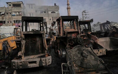Palestinians examine the remains of bulldozers hit by an Israeli army airstrike in Jabaliya, northern Gaza Strip, April 22, 2025. (AP Photo/Jehad Alshrafi)
