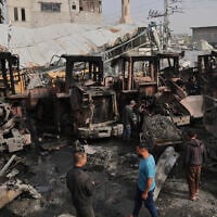 Palestinians examine the remains of bulldozers hit by an Israeli army airstrike in Jabaliya, northern Gaza Strip, on Tuesday, April 22, 2025. (AP Photo/Jehad Alshrafi)