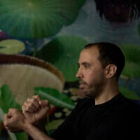 Freed Israeli hostage Tal Shoham, who was held by Hamas militants in the Gaza Strip, demonstrates how his captors handcuffed him, in Tel Aviv, Israel, Tuesday, April 22, 2025. (AP Photo/Maya Alleruzzo)