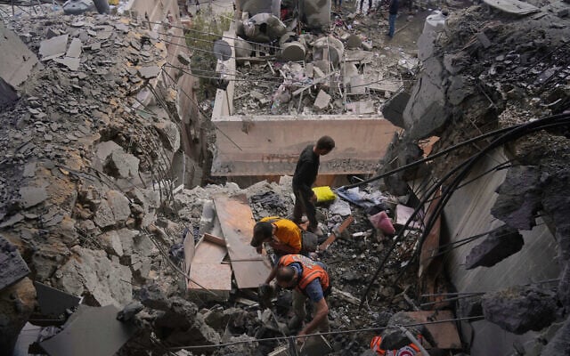Palestinian men search through the debris following an Israeli strike on a residential building in Gaza City, April 24, 2025. (AP Photo/Jehad Alshrafi)