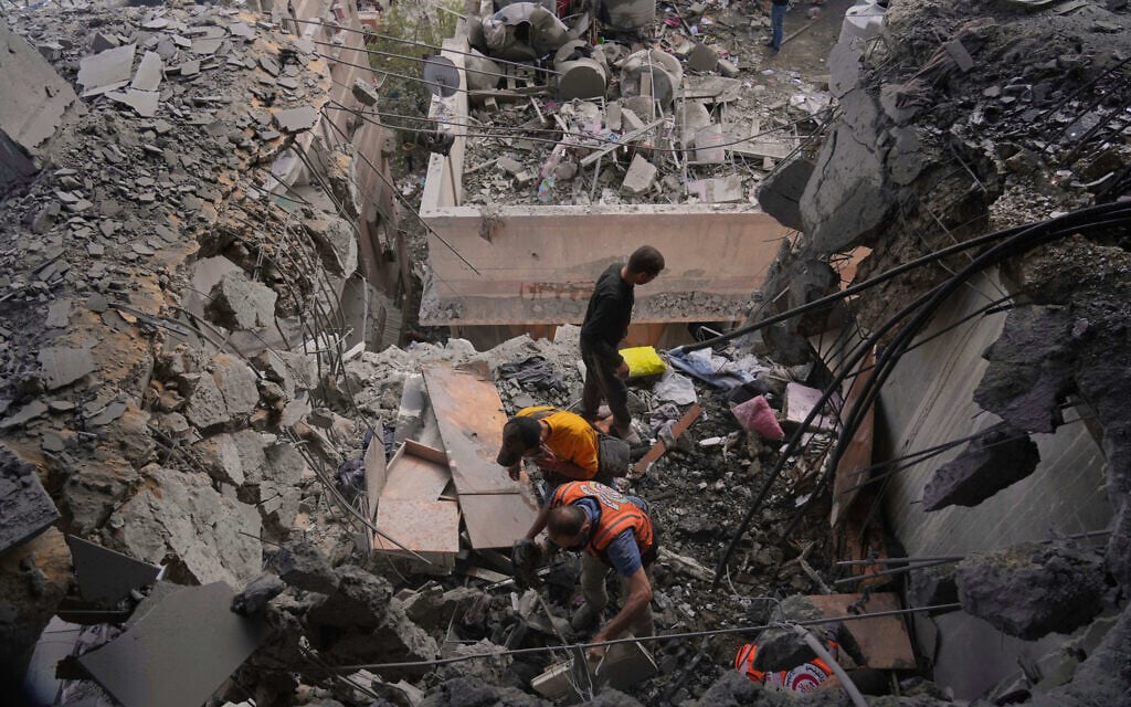 Palestinian men search through the debris following an Israeli strike on a residential building in Gaza City, April 24, 2025. (AP Photo/Jehad Alshrafi)