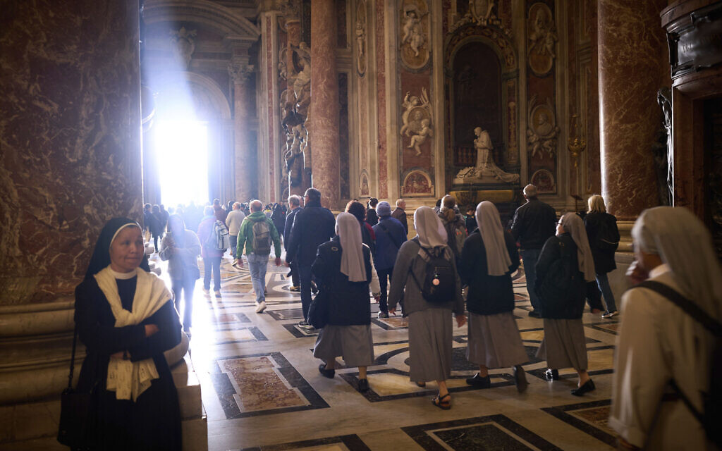 People walk at St. Peter's Basilica where Pope Francis lying in state, at the Vatican, April 25, 2025. (AP Photo/Emilio Morenatti)