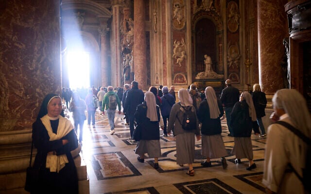 People walk at St. Peter's Basilica where Pope Francis lying in state, at the Vatican, April 25, 2025. (AP Photo/Emilio Morenatti)