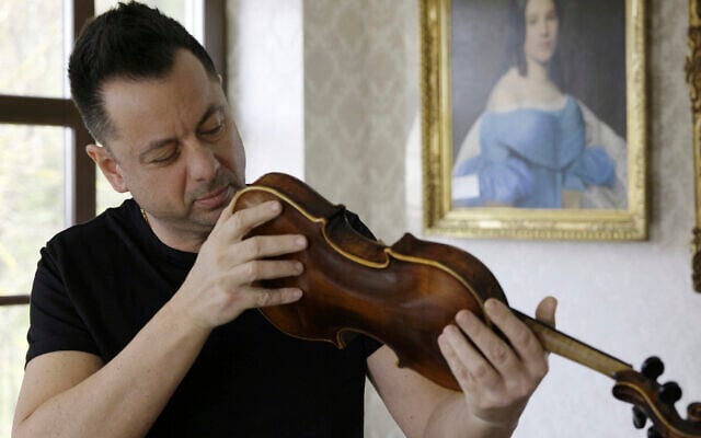 Art collector Tamás Tálosi holds the ''violin of hope'', in Magyarpolány, Hungary, April 22, 2025. (/Nikolett Csanyi / AP)
