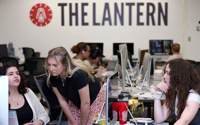 Emma Wozniak, editor in chief of the Ohio State University's The Lantern newspaper, talks with Nora Igelnik, campus editor at the paper's office in Columbus, Ohio, April 24, 2025, as managing editor of content, Lucy Lawler listens. (AP Photo/Joe Maiorana)