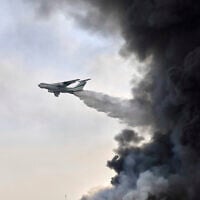 An Islamic Revolutionary Guards Corps firefighting air-tanker drops water on Sunday, April 27, 2025, after a massive explosion and fire rocked a port near the southern port city of Bandar Abbas, Iran, a day earlier. (AP Photo/Mahdi Nori/Fars News agency)
