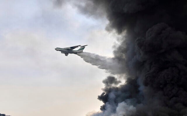 An Islamic Revolutionary Guards Corps firefighting air-tanker drops water on Sunday, April 27, 2025, after a massive explosion and fire rocked a port near the southern port city of Bandar Abbas, Iran, a day earlier. (AP Photo/Mahdi Nori/Fars News agency)